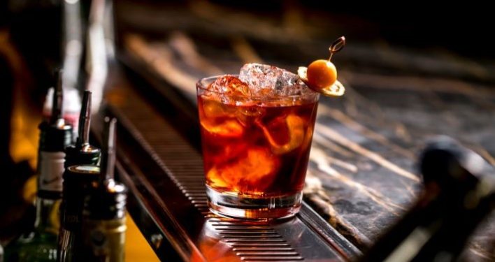 cocktail glass with ice cubes garnished with dried lemon fruit