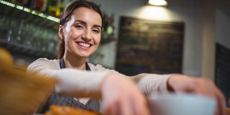waitress-serving-cup-coffee-customer-caf 0 tendencias en bienestar laboral que van a redefinir la hostelería