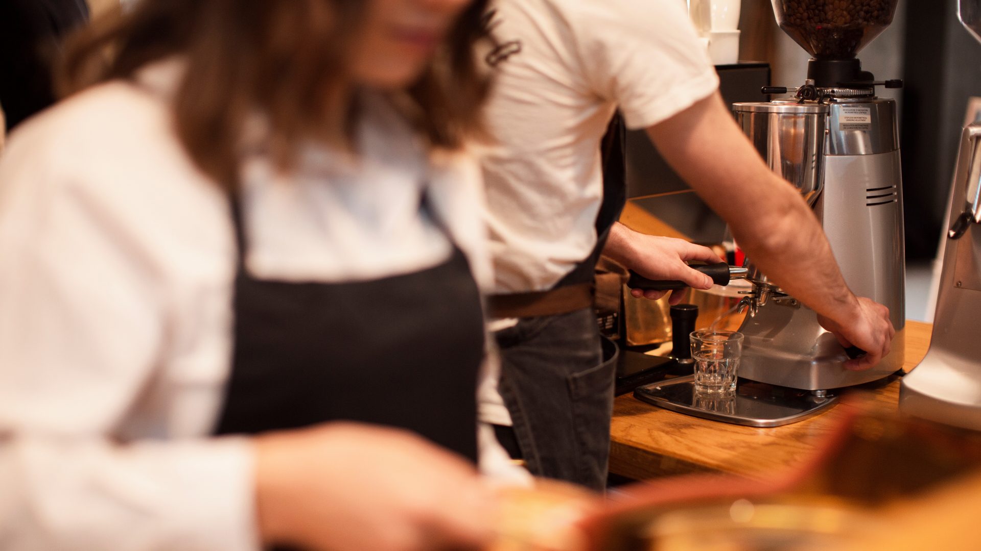 Plano cerrado de dos camareros realizando labores en barra