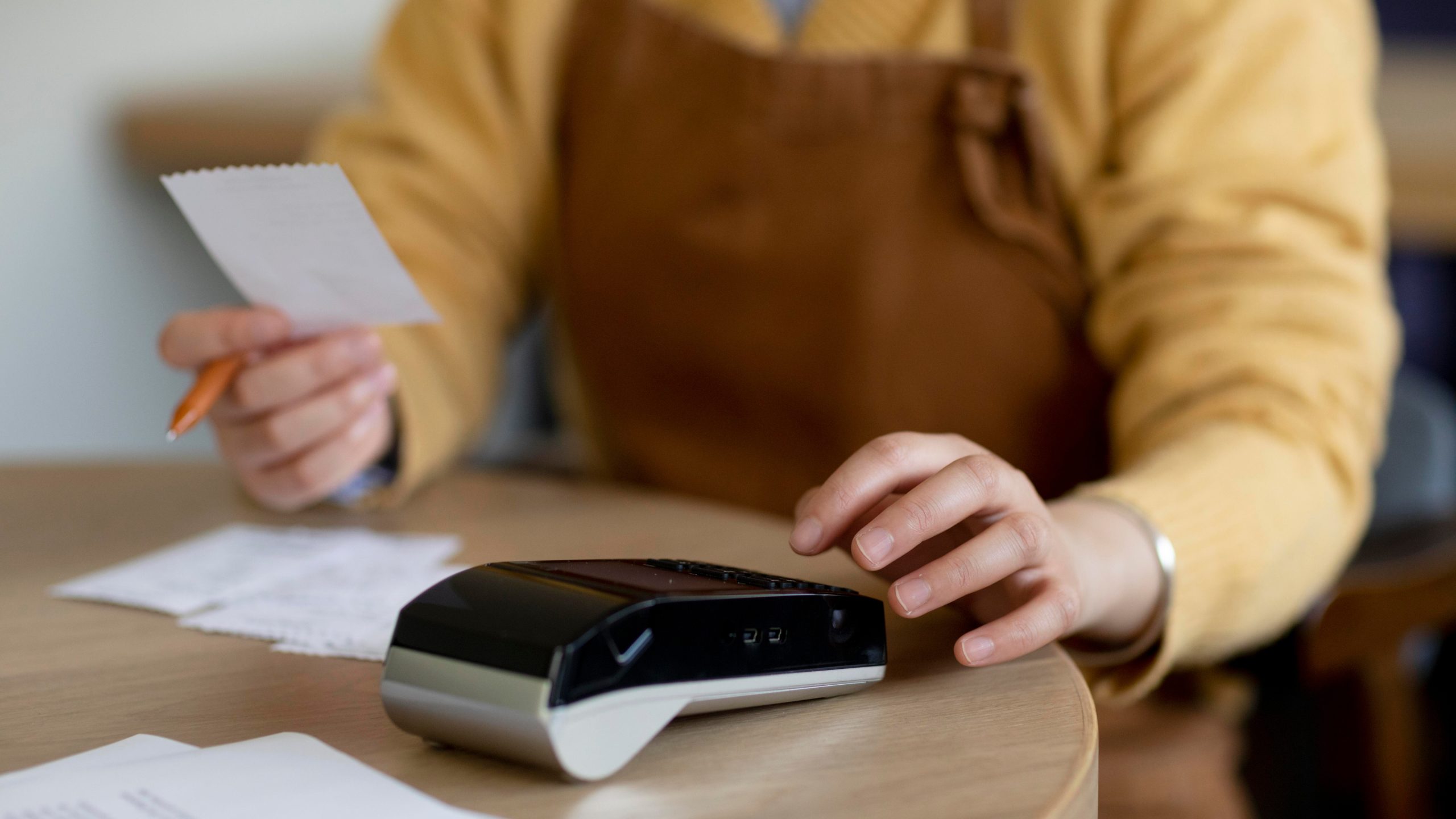 Verifactu: ¿Qué es y qué debo saber si tengo un restaurante? Persona cerrando el balance del negocio con un TVP y una hoja y boligráfo.