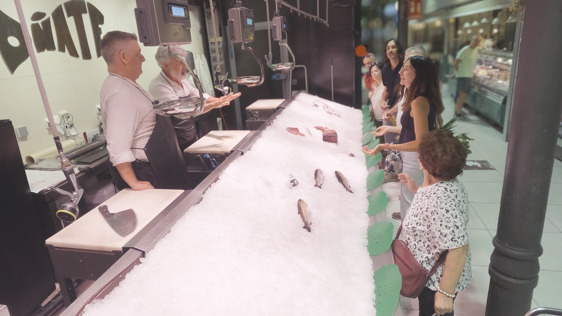 Personas intentando comprar pescado ante un mostrador desabastecido.
