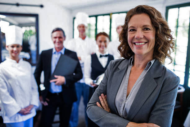 Portrait of happy female manager standing with arms crossed in restaurant istockphoto 698583336 612x612 1