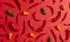 Chiles y jalapeños dispuestos en un fondo rojjo.